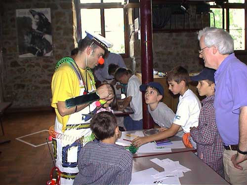 the clown, and adult helper and a group of kids on the first game